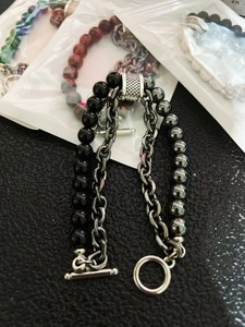Detail of layered bracelet with black beads, silver metal chain and T-bar toggle clasp