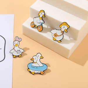 Cartoon yellow duck enamel pin set with various cute poses on a white display stand