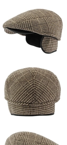 Detail of vintage brown plaid flat cap featuring thick wool fabric and ear protection