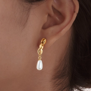 Elegant gold chain earrings with teardrop pearl pendants shown on model