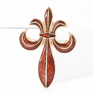 Close-up of golden fleur-de-lis brooch with red-brown leopard print enamel detail