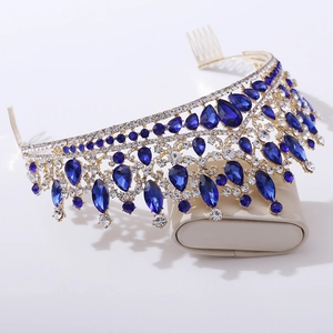Close-up of golden crown hair comb with blue water-drop rhinestones and silver crystals