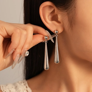 Elegant silver teardrop earrings with a polished metallic finish on female model