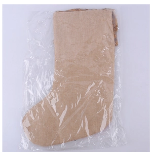 Detail of beige burlap Christmas stocking with brown faux fur trim in clear packaging