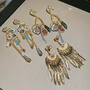 Detailed macro of vintage Bohemian long tassel earrings with colorful beads and gold charms
