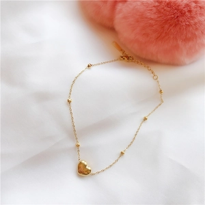 Minimalist gold heart charm bracelet for women featuring polished steel beads and link chain