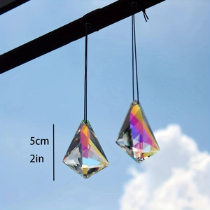 Detailed view of a 5cm rainbow crystal suncatcher prism hanging against a clear blue sky