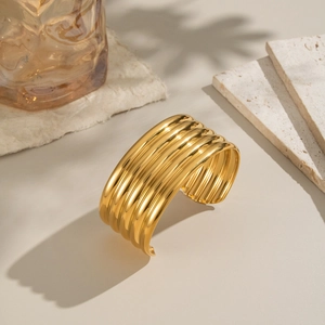 Detailed view of wide 18K gold plated cuff bracelet with vertical striped texture