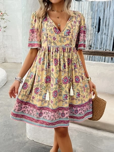 Detail of bohemian floral print dress with V-neckline and tassel drawstring waist detail
