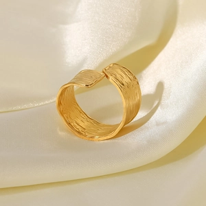Detailed close-up of 18K gold plated stainless steel ring with hammered texture on silk