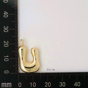Detailed view of golden balloon letter U pendant showing 22mm height on measuring ruler
