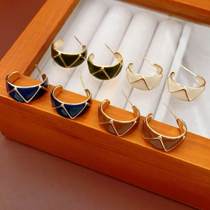Detail of four pairs of vintage enamel C-shaped earrings in blue green white and brown