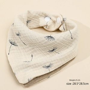 Detail of four-layer cotton baby bib featuring dandelion pattern and snap buttons
