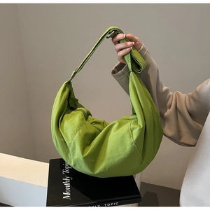 Close-up of bright green nylon crossbody bag in a minimalist indoor setting