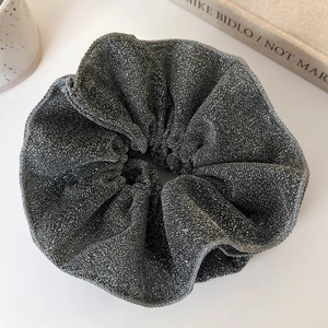 Close-up of a shimmering grey double-layered lace scrunchie on a clean white background