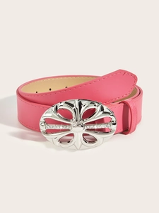 Detail of pink leather belt with silver rhinestone flower buckle on beige background