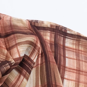 Close-up detail of brown and beige plaid pattern on lightweight chiffon fabric
