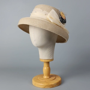 UPF 50+ sun protection straw hat with elegant chiffon bow and pearls on a display stand