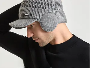 Détail d'un bonnet d'hiver en tricot gris clair avec protège-oreilles et visière