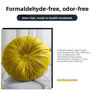 Detail of yellow round velvet pumpkin cushion with handcrafted pleats on a golden chair