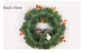 Detail view of a green Christmas wreath featuring a bronze deer head and festive berries