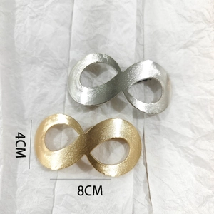 Macro detail of infinity shaped metal hair clips with brushed gold and silver finish