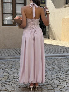 Detail of elegant pink halter neck maxi dress with lace-up back design on a model
