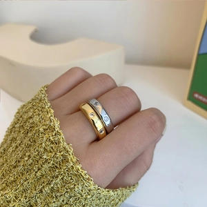 Primer plano de anillos de latón bañados en oro y plata con tres pequeñas circonitas