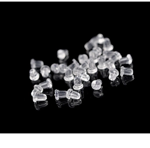 Macro shot of clear silicone earring backings on a reflective black background