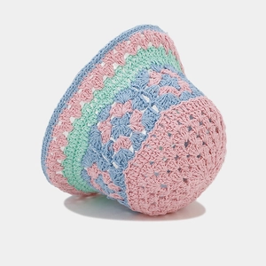 Detail of hand-crocheted bucket hat with hollow flower pattern in pink, blue, and green