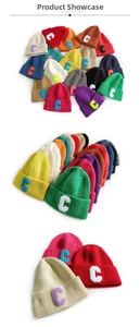 Detailed view of ribbed knit beanies with large C-letter patches in various vibrant colors
