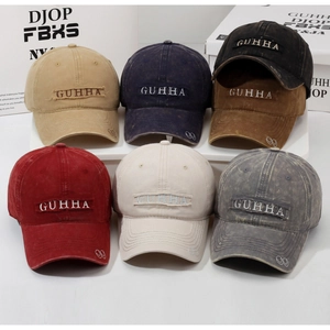Close-up of vintage washed cotton baseball caps in six colors with GUHHA embroidery