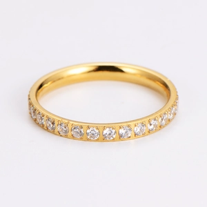 Macro detail of gold plated eternity ring featuring pavé set crystals on white background