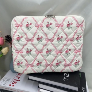 Close-up of quilted floral tablet sleeve with pink roses, bow prints and dual metal zippers