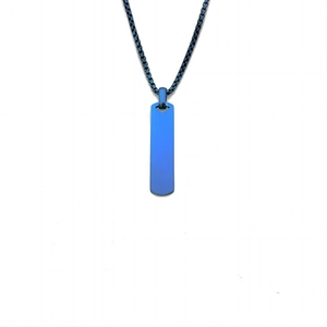 Détail d'un pendentif rectangulaire bleu sur une chaîne boîte noire sur fond blanc neutre
