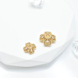 Macro shot of 18k gold plated snowflake bead caps with sparkling zircon insets