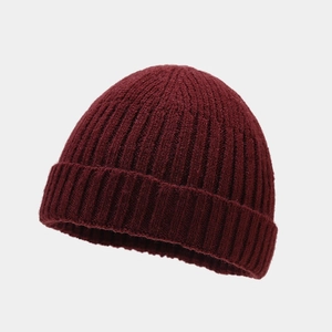 Makro-Detail der weinroten Rippstrick-Beanie mit Fokus auf die Wollstruktur