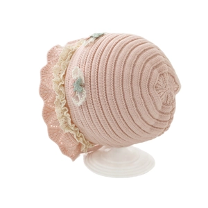 Pink knit baby beanie with cream lace trim and floral embroidery on a white background