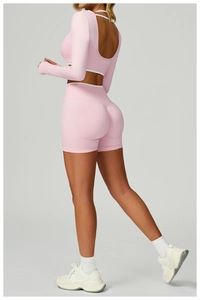 Detail of pink backless yoga top and high-waisted shorts with white contrast trim