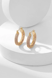 Detailed view of gold plated hoop earrings featuring three rows of pink zircon stones