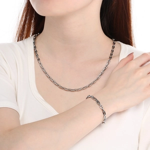 Model wearing a set of silver stainless steel pig nose chain necklace and bracelet