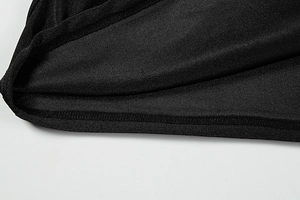 Makroaufnahme der Overlock-Naht auf schwarzem Strickstoff mit feiner Textur am Saum