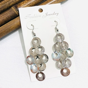 Detail view of multi-layered silver metal hoop drop earrings with bohemian style