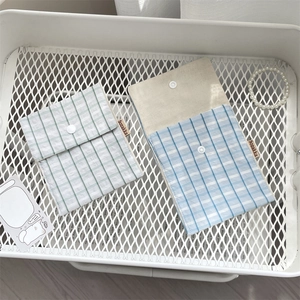 Detailed view of floral cotton sanitary pouch with snap button and woven label on metal tray