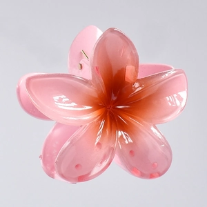 Macro detail of 7cm pink gradient plumeria hair claw clip with durable metal spring