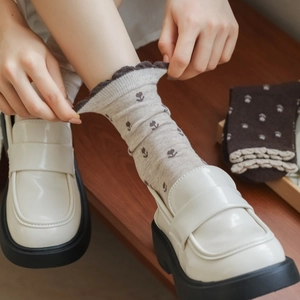 Détail de chaussettes en coton à motif tulipe vintage avec revers à volants beige et brun