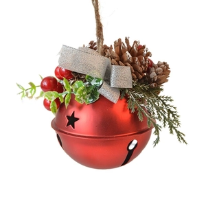 Red matte Christmas bell ornament with pinecones, berries, and silver bow on white background