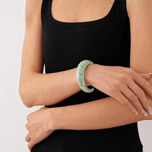 Detail of light green acrylic swirl cuff bracelet with vintage geometric twisted texture