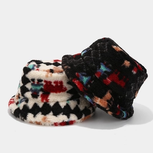 Detail showing plush bucket hats in black and white with colorful geometric patterns