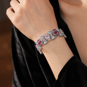 Détail d'un bracelet vintage en argent avec pierres roses et bleues sur un poignet